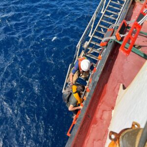 Seafarers help the stranded boaters climb aboard the El Coqui - Crowley