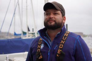 Ben Carver, Baltimore harbor environmental education program captain at the Chesapeake Bay Foundation, speaks about oyster restoration aboard the Snow Goose. (Photo by Christine Condon/ Maryland Matters)