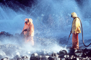 Prince William Sound, AK (Mar. 28)--Workers steam blast rocks soaked in crude oil from the leaking tanker Exxon Valdez. The Exxon Valdez ran aground on Bligh Reef in Prince William Sound, Alaska, March 23, 1989 spilling 11 million gallons of crude oil, which resulted in the largest oil spill in U.S. history. U.S. COAST GUARD PHOTO